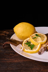 Grilled fish with herbs and lemon on wooden background. Mediterranean luxurious seafood concept