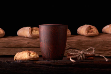 Cookies with cottage cheese and milk on wooden table background. Mini pies in desk. Rustic style.
