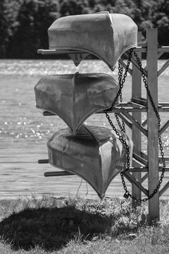 Three Canoes/A black and white photo of three canoes by the lake on a summer day. 