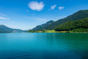 Türkiser See mit Bergen und Wolken am blauen Himmel in Österreich mit dem Namen Wolfgangsee
