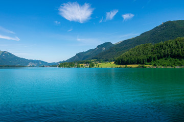 Türkiser See mit Bergen und Wolken am blauen Himmel in Österreich mit dem Namen Wolfgangsee