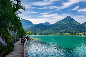 Steg entlang am See in Österreich welcher Wolfgangsee genannt wird mit Berge im Hintergrund und...