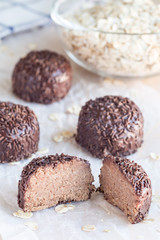 Swedish sweets Arrack balls, made from cookie crumbs, cocoa, butter and coconut wine Arrack flavour, on a wooden table, vertical