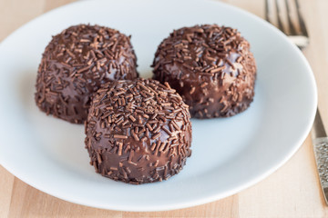 Swedish sweets Arrack balls, made from cookie crumbs, cocoa, butter and coconut wine Arrack flavour, on a wooden table, horizontal