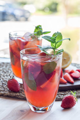 Homemade iced tea with strawberries and mint, vertical