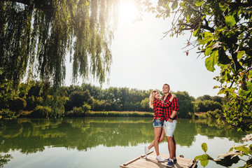 Romantic couple relaxing on a wooden jetty near a river