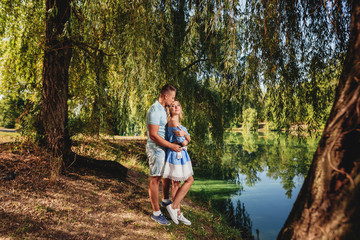 Fototapeta na wymiar Happy couple on the walk near the river in the forest . Love story