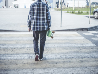 young man's back walking on the crosswalk