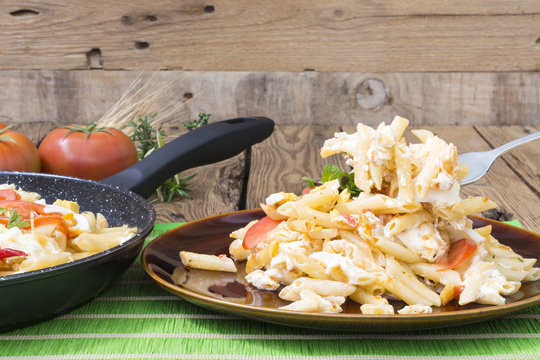 Un tenedor sobre un plato de macarrones cocinados con queso y verduras
