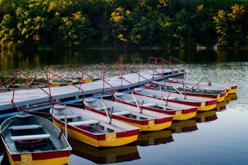 Pleasure rowing boats moored at the pier in the evening pond. Donetsk. Ukraine.