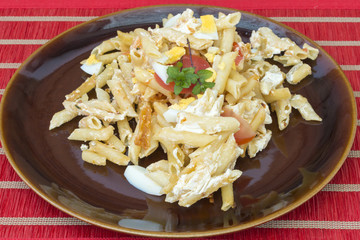 Un plato de macarrones cocinados con queso y verduras