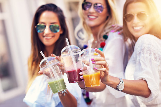 Happy girl friends hanging out in the city in summer