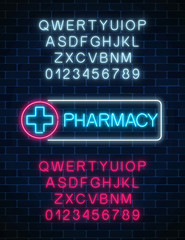 Neon pharmacy glowing signboard with two different colors alphabets. Illuminated drugstore sign open 24 hours.