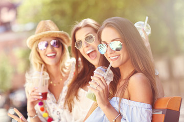 Happy girl friends hanging out in the city in summer