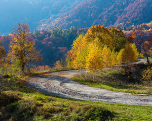 Naklejka na ściany i meble Dirty secondary road in autumn Carpathian mountain, Ukraine