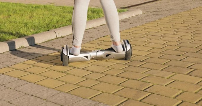 Female, girl without shoes ride on hoverboard, gyroscooter and turning.