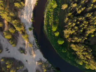 top view to bending river in green forest  on sunset