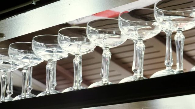 Empty clean glasses for drinks standing on the bar counter in the restaurant. 4K