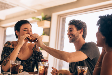Friends having stack burger at cafe
