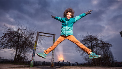 kid leaps in sunset at playground