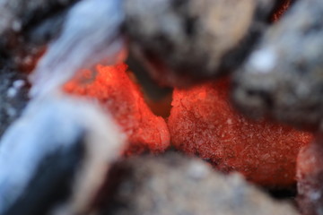 Glowing coals to hotdog grill with a charcoal barbecue in the garden
