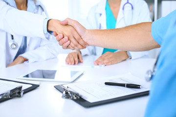 Two doctors shaking hands to each other at meeting. Teamwork and agreement in medicine