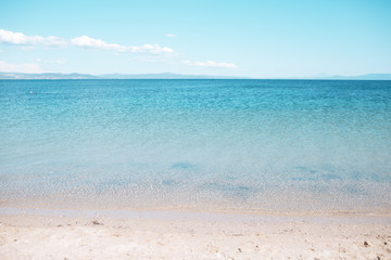 Sea beach with white sand and turquoise water. Seascape on sunny blue sky. Summer vacation in...