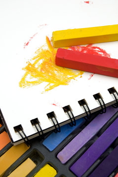 Vertical Image of Colorful Pastel Crayons and Coloring Book