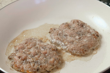 Frying on the pan cutlets for burgers. Close-up.