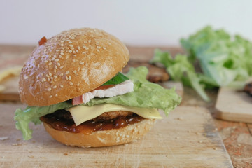 Burger with buns, cutlets, cheese, salad, on the wood board