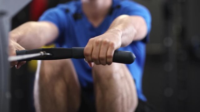 Slow Motion Sequence Of Man In Gym Exercising On Rowing Machine
