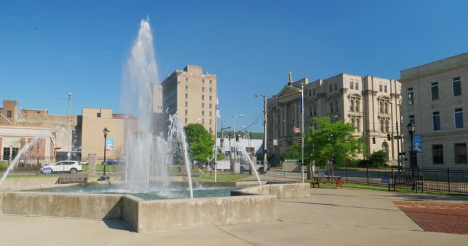 A daytime static establishing shot (DX) of the small town of Steubenville, Ohio on a sunny summer morning as seen from the fountain near Historic Fort Steuben.  	