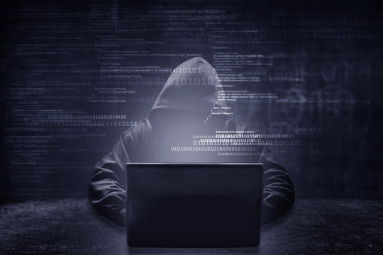 Internet crime concept. Hacker working on a code on dark digital background with digital interface around.