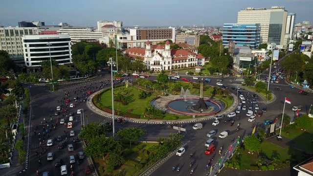 Static drone shot of busy roundabout and popular Lawang Sewu (Dutch) colonial building in Semarang, tourism and transportation Indonesia