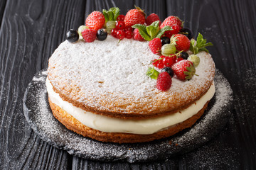 Freshly baked holiday Victoria sandwich cake with berries and mint closeup. horizontal