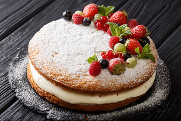 Victoria sandwich cake with strawberries, raspberries, gooseberries, currants and mint closeup. horizontal