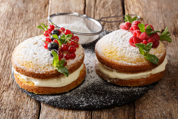 English Victoria sandwich cake with fresh berries and mint closeup. horizontal