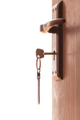 Door keys hanging from keyhole on the wooden door. Isolated on white background.