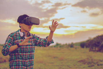 Man in Tartan Shirt wearing Virtual Reality headset reality in beautiful sky nature and technology concept