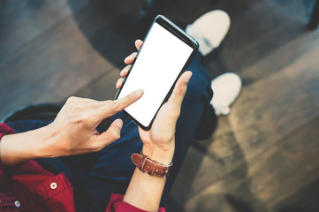 Close up of male hands holding touching mobile phone with blank copy space for your text message in cafe with light Sunset,Vintage tone.Selective focus