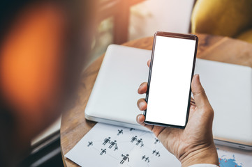 Close up of men and woman hands holding touching mobile phone with blank copy space for your text message in cafe with light Sunset,Vintage tone.Selective focus