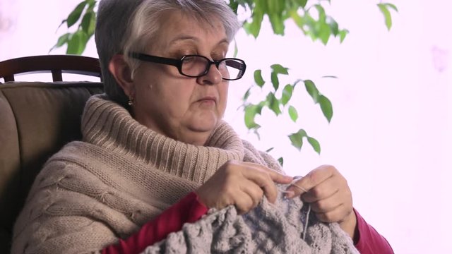 Senior woman hands knitting with wool, grandmothers hands knit wool yarn. craft is hobby of old women. senior lady, granny knitted sweater handmade. needle pattern from thread loop.close-up