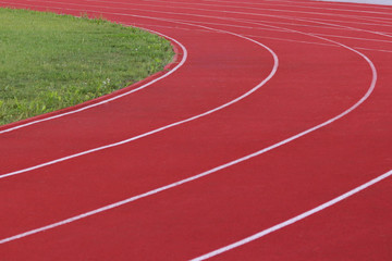 Red treadmill on the football field. Open stadium for sports competitions. Active and healthy lifestyle. Forward movement. Olympic competitions. Leisure of the population. Road marking.