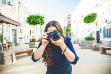 Beautiful woman tourist walking on the street with a camera and photographed close-up Exploring the city.