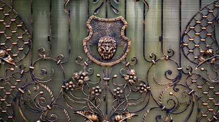 Details, structure and ornaments of forged iron gate. Decorative ornamen with lions , made from...