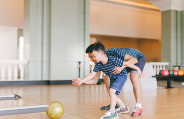 Asian family having fun at bowling club