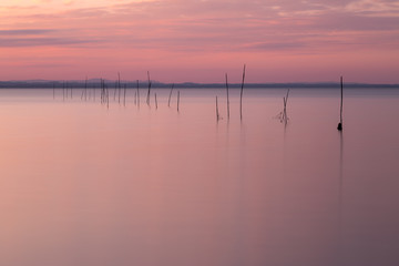 Fototapeta na wymiar A minimalistic view of a lake at sunset, with warm light and ton