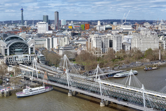 Aerial view of Hungerford Bridge, a steel truss railway bridge, flanked by the Golden Jubilee Bridges, two cable-stayed pedestrian bridges over the River Thames in London, England, UK