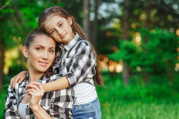 Fototapeta premium Mother and daughter walking in a park on summer day