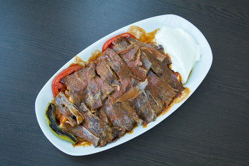 iskender kebab on a wooden surface at a restaurant top view.